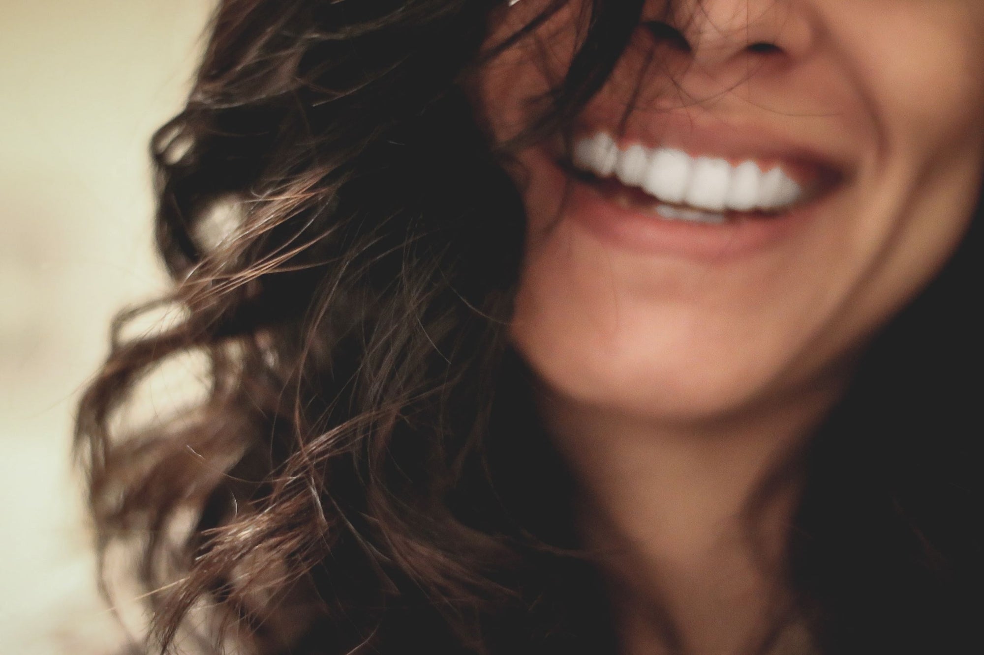 Detalhe de cabelo com cachos e mulher sorrindo